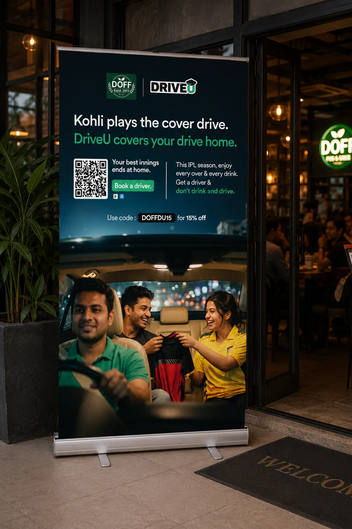DriveU and DOFF co-branded IPL standee at a bar entrance: Kohli plays the cover drive, DriveU covers your drive home