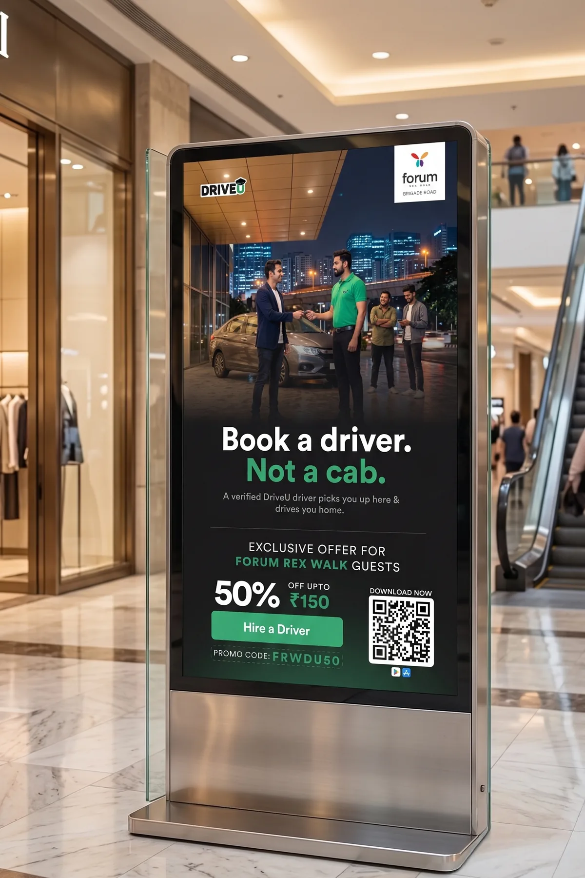 DriveU digital standee in a mall reading Book a driver, not a cab, with a Forum Rex Walk partner offer